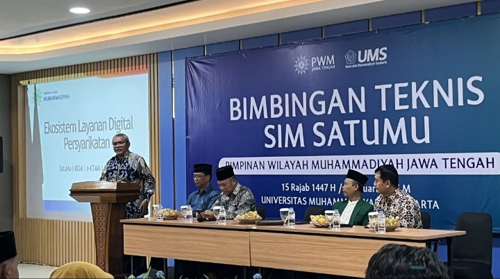 Suasana Bimbingan Teknis SIM SatuMu di Edutorium UMS, menampilkan pimpinan di meja depan dengan latar belakang spanduk biru besar bertuliskan Bimbingan Teknis SIM SatuMu Pimpinan Wilayah Muhammadiyah Jawa Tengah.