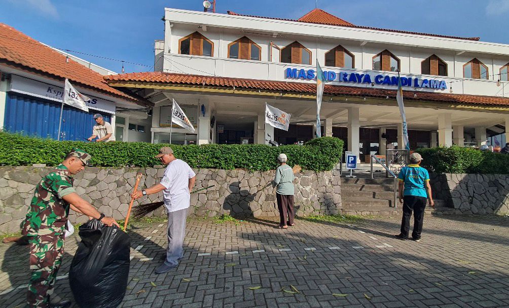 Warga dan petugas Kelurahan Kaliwiru bekerja bakti melakukan resik-resik di halaman Masjid Raya Candi Lama Semarang menggunakan sapu lidi dan kantong sampah.
