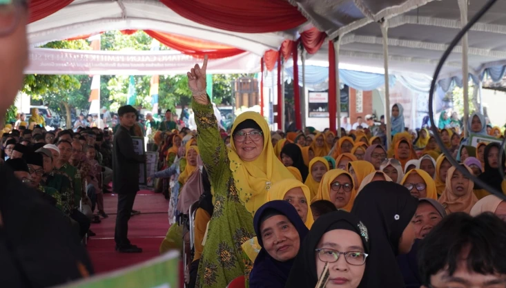 Seorang ibu anggota Aisyiyah tersenyum sambil mengangkat tangan dengan antusias saat mengikuti lelang Masjid Muhammadiyah Semarang untuk donasi pembangunan Masjid At-Taqwa Dong Biru.