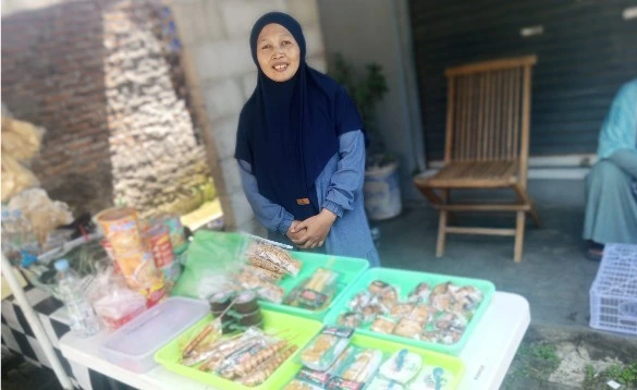 Siti Rumiyati, pelaku UMKM lokal penjual es teh dan jajanan, tersenyum ramah di lapak dagangannya yang laris manis saat perhelatan Hari Ber-Muhammadiyah di Kecamatan Genuk.