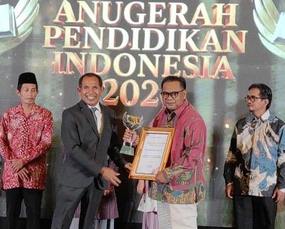 Kepala SMK Muhammadiyah 1 Semarang menerima trofi dan piagam penghargaan Sekolah Inovatif dalam ajang Anugerah Pendidikan Indonesia 2026 di Quest Hotel Semarang.