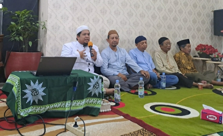 Seorang ustaz atau pembicara berbaju putih dan peci putih sedang memberikan kajian dakwah menggunakan mikrofon di depan pengurus Muhammadiyah Kota Semarang.