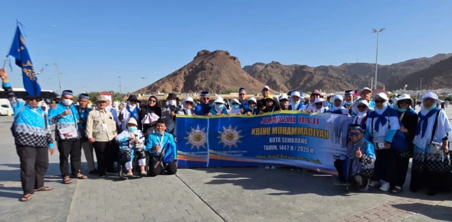 Rombongan jemaah haji KBIHU Muhammadiyah Kota Semarang membentangkan spanduk saat kegiatan city tour di kawasan Jabal Uhud, Madinah.
