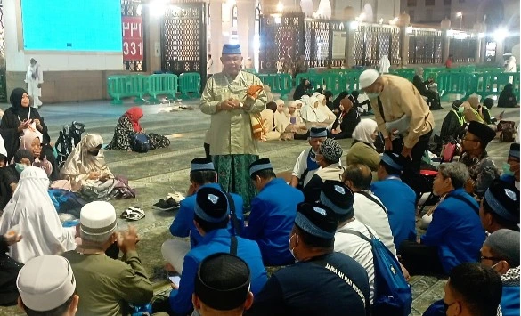Dr. Mafrukhi memberikan arahan persiapan ihram kepada jemaah haji 2026 KBIHU Muhammadiyah Semarang di pelataran Masjid Nabawi.