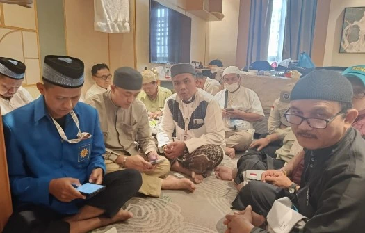 Suasana para Ketua Rombongan (Karom) dan Ketua Regu (Karu) jemaah haji duduk lesehan mengikuti rapat koordinasi bersama PPIH Kloter 28 SOC Semarang untuk membahas penyesuaian jadwal akibat larangan city tour haji 2026.