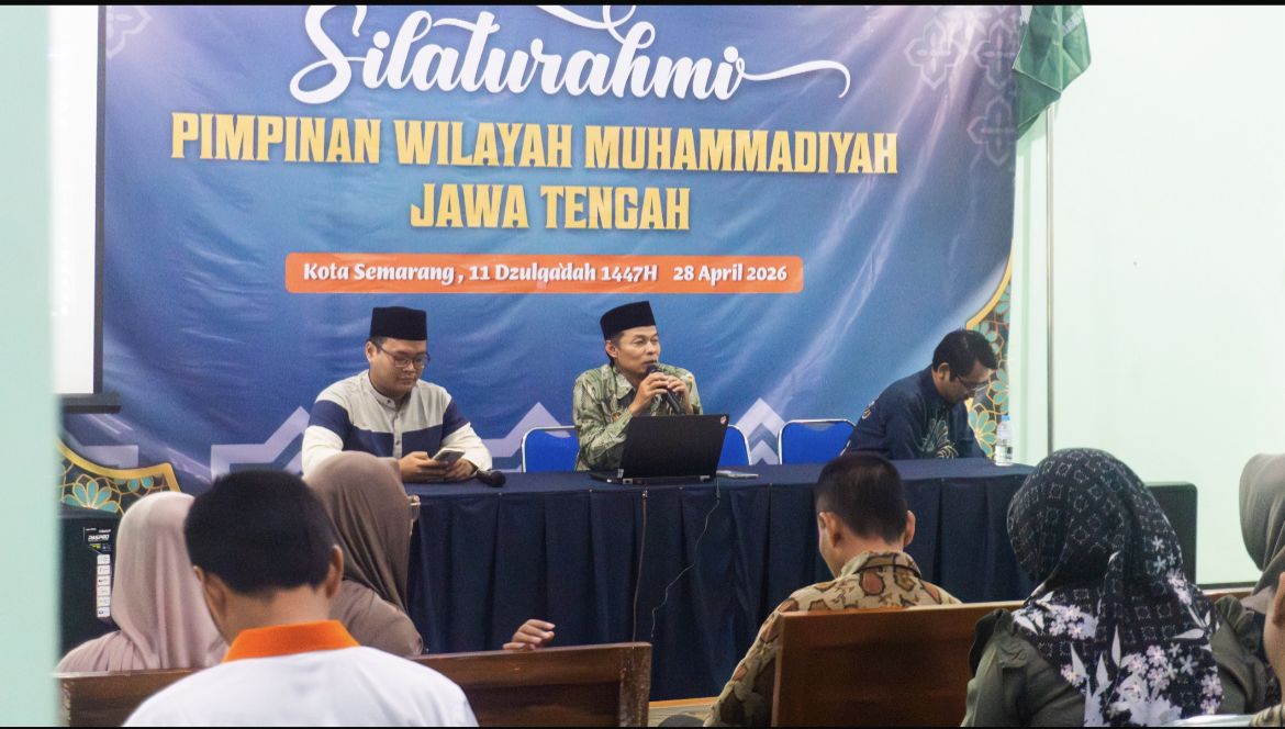 Foto dokumentasi forum koordinasi Lazismu di sebuah ruangan pertemuan. Di bagian depan, terdapat tiga orang narasumber pria duduk di belakang meja panjang yang ditutupi kain biru tua. Narasumber di tengah mengenakan baju batik hijau sedang berbicara menggunakan mikrofon, didampingi narasumber di sisi kiri yang mengenakan kemeja biru-putih dan peci hitam, serta narasumber di sisi kanan yang mengenakan kemeja biru tua. Di latar belakang terdapat spanduk besar berwarna biru dengan tulisan "Silaturahmi Pimpinan Wilayah Muhammadiyah Jawa Tengah". Di depan meja narasumber, terlihat punggung beberapa peserta yang sedang menyimak pemaparan.
