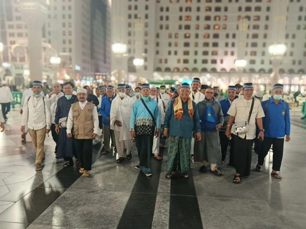 Rombongan jemaah haji laki-laki Kloter 28 SOC Semarang berjalan beriringan melintasi pelataran Masjid Nabawi menuju makam Rasulullah untuk melaksanakan Ziarah Wada.