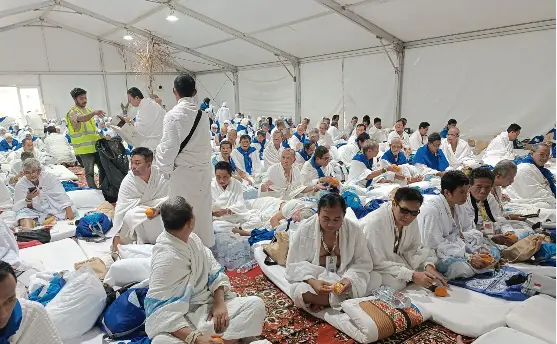 Jemaah haji Muhammadiyah Semarang Kloter 28 SOC duduk santai menikmati fasilitas kasur dan menerima pembagian makanan di dalam tenda Arafah ber-AC jelang wukuf.
