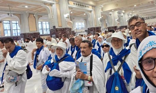 Rombongan jemaah haji Semarang Kloter 28 SOC mengenakan kain ihram putih dan syal biru bersiap melaksanakan umrah wajib gelombang pertama di dalam pelataran Masjidil Haram pada Ahad pagi.