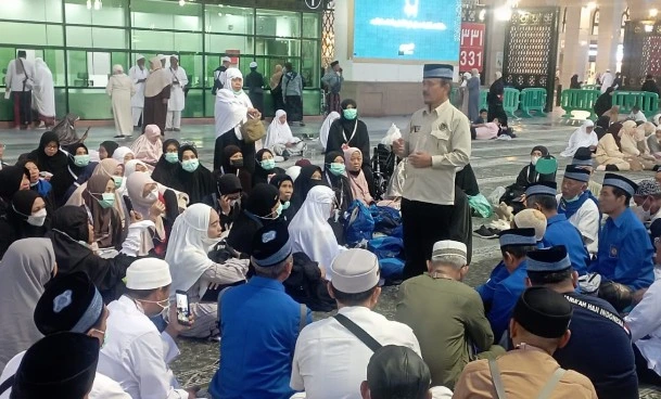 Ustadz Nurbini memberikan pengarahan tentang niat ihram bersyarat kepada jemaah haji Semarang di pelataran Masjid Nabawi.