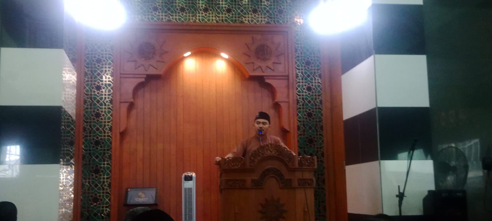 Ustadz Mirza sedang menyampaikan Kultum Dzuhur mengenai keutamaan puasa Muharram di atas mimbar kayu Masjid At-Taqwa PDM Kota Semarang.