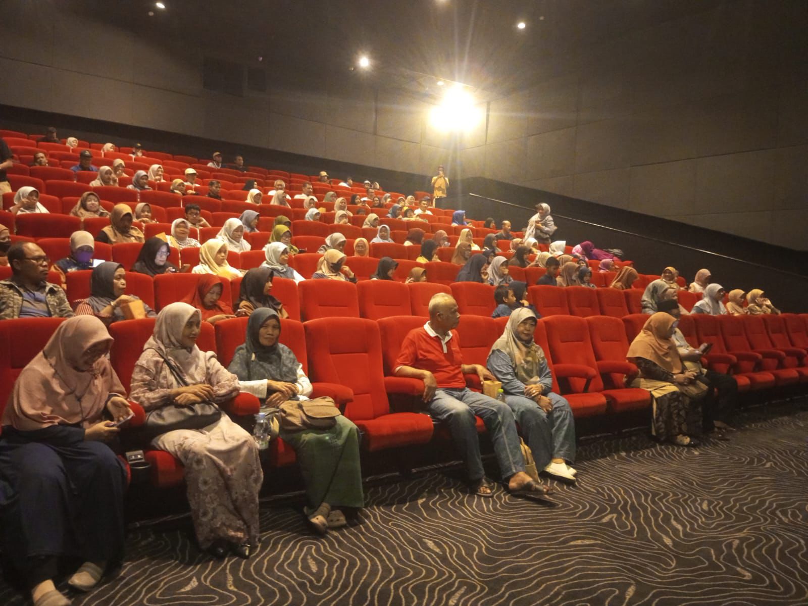 Suasana deretan kursi merah bioskop yang dipenuhi oleh jemaah perempuan berhijab dan bapak-bapak kader PDM serta Aisyiyah Semarang saat acara nonton bareng.