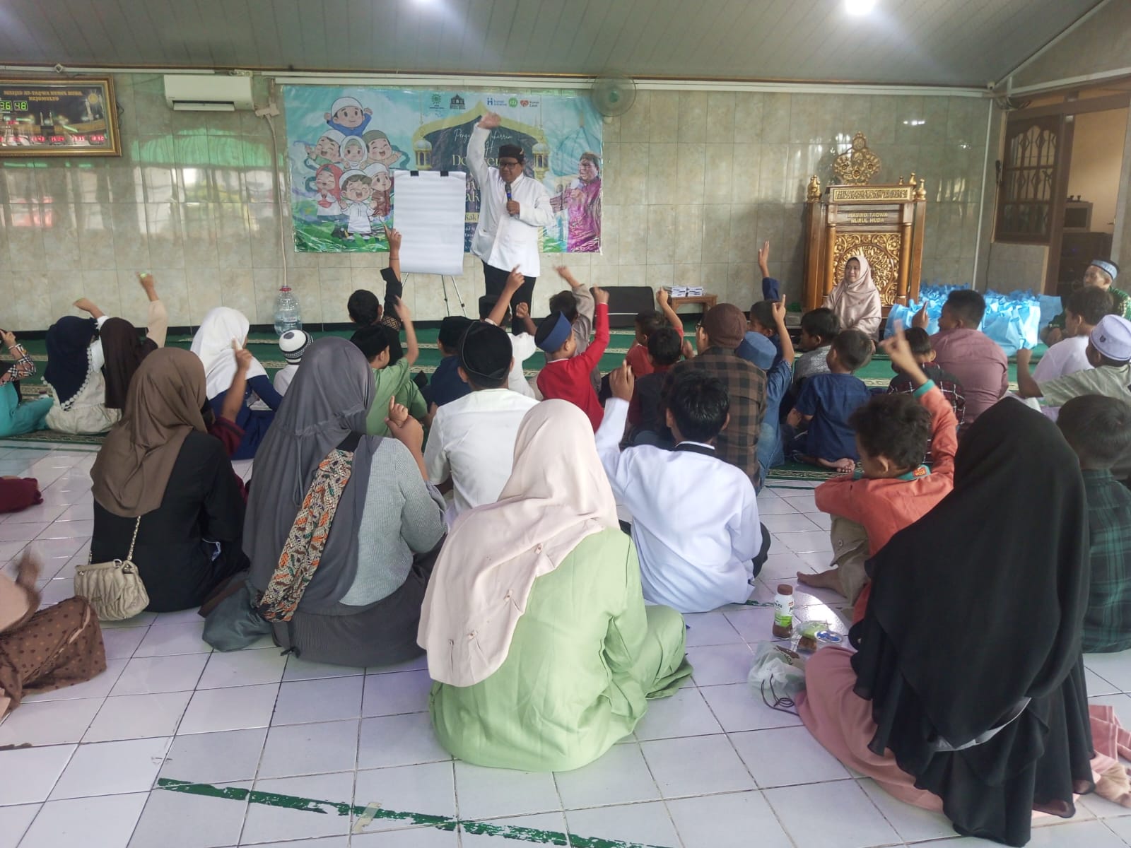 Suasana program santunan anak yatim di Masjid At-Taqwa Nurul Huda Semarang saat Kak Kempho Antaka sedang mendongeng di hadapan anak-anak.