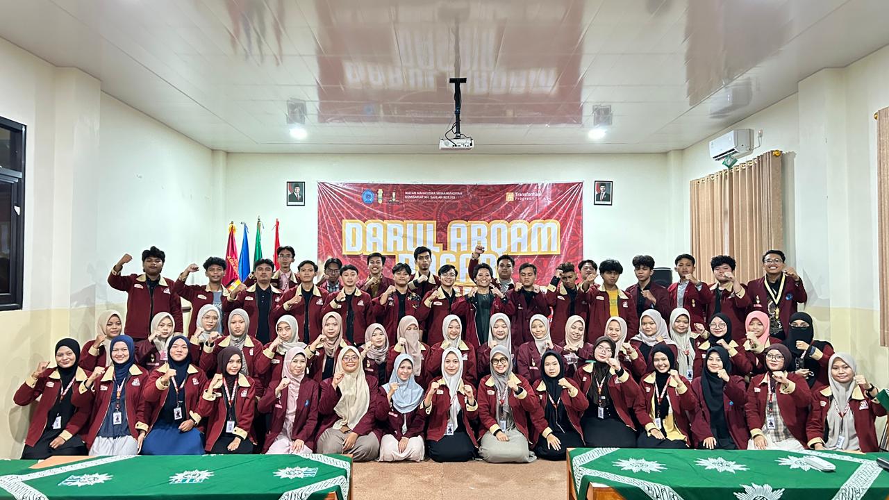 Puluhan mahasiswa dan mahasiswi kader Muhammadiyah berfoto bersama dengan pose mengepalkan tangan dalam acara dad perdana imm KH Sahlan Rosjidi Unimus. Mereka mengenakan jas almamater merah marun khas IMM di sebuah ruang kelas dengan latar belakang spanduk bertuliskan "DARUL ARQAM DASAR".
