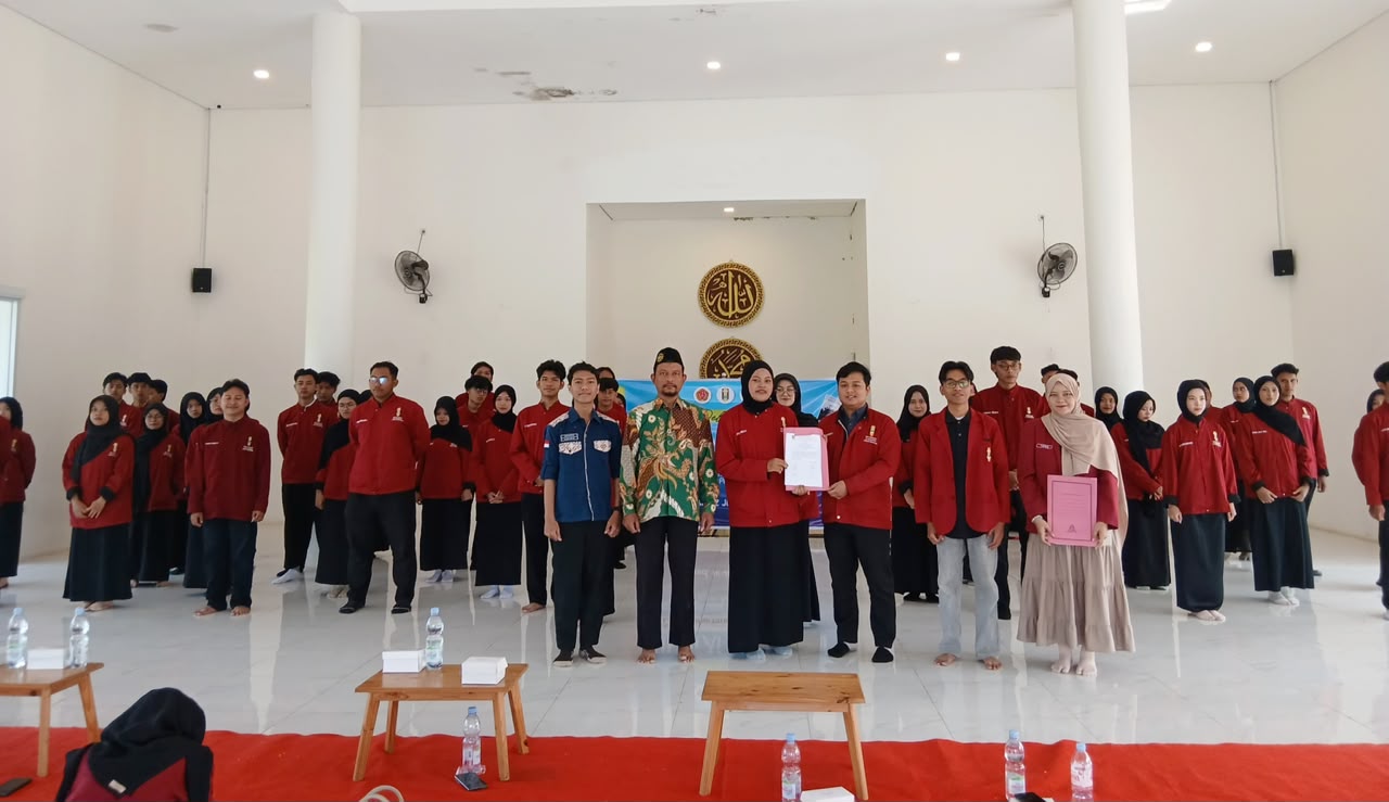 Jajaran pengurus dan pimpinan PK IMM Al-Khawarizmi berfoto bersama setelah prosesi pelantikan pengurusan baru demi menjaga eksistensi kader muhammadiyah di lingkungan kampus. Puluhan mahasiswa dan mahasiswi mengenakan jas almamater merah marun berdiri berjejer di dalam aula berlantai putih yang megah.