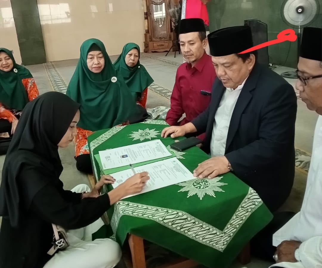 Perempuan berhijab hitam menandatangani dokumen ikrar syahadat dipandu oleh tokoh Muhammadiyah di Masjid At-Taqwa Semarang sebagai puncak perjalanan spiritual mualaf.