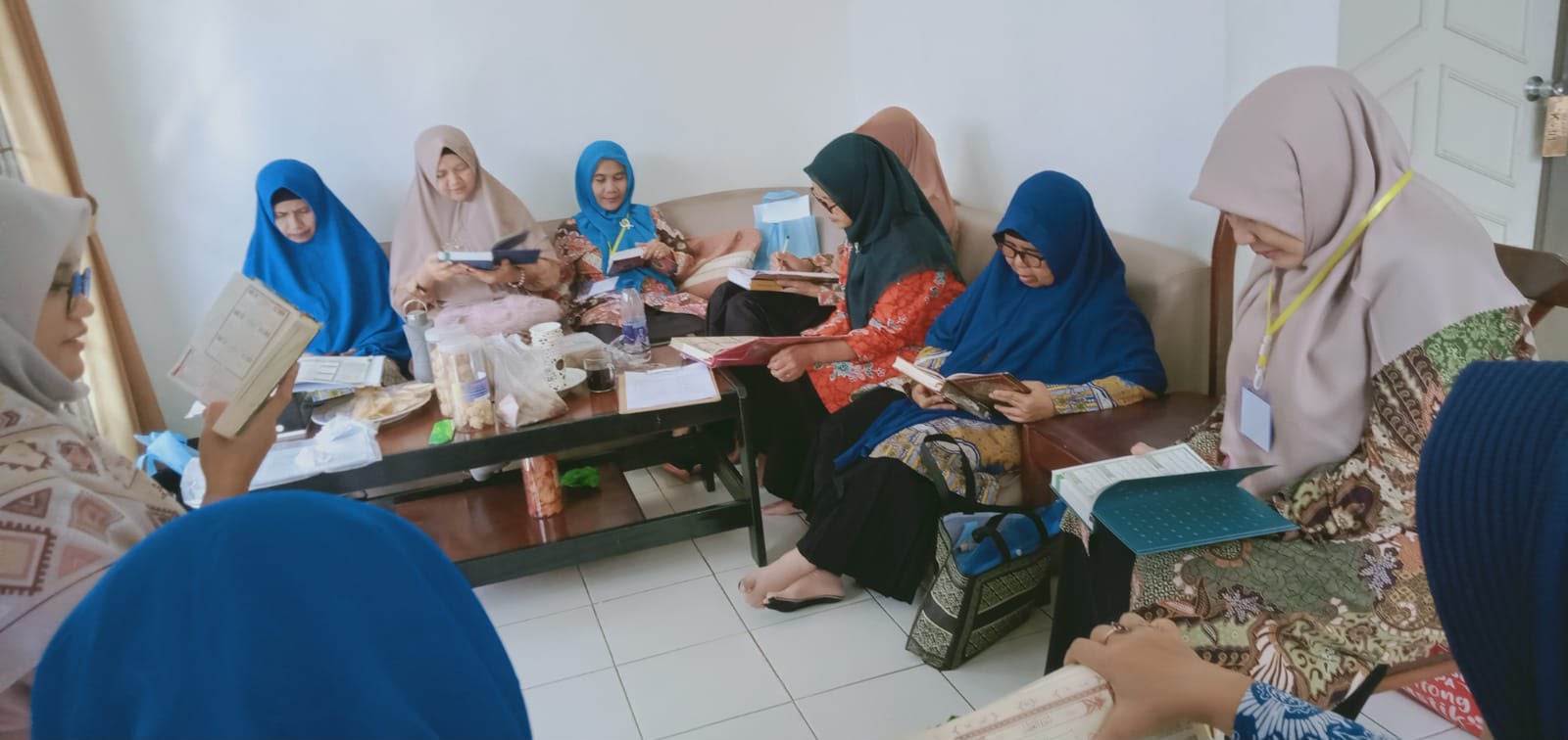 Sekelompok ibu-ibu pimpinan Aisyiyah Kota Semarang mengenakan hijab sedang duduk bersama, fokus membaca buku panduan dan belajar Tahsin Alquran dalam kegiatan Camp Qur'an di Bandungan.