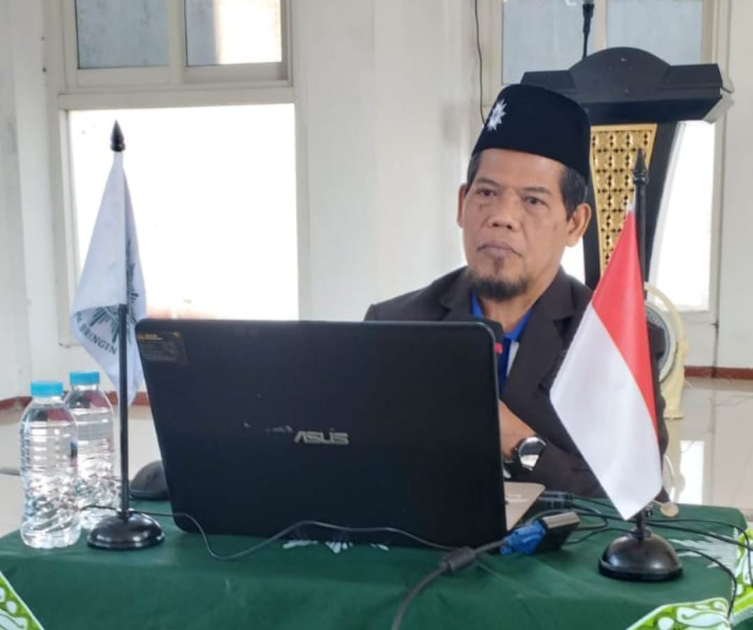 Drs H Danusiri MAg duduk di depan laptop memaparkan materi Islam Berkemajuan untuk meraih ketenangan batin dalam Islam.