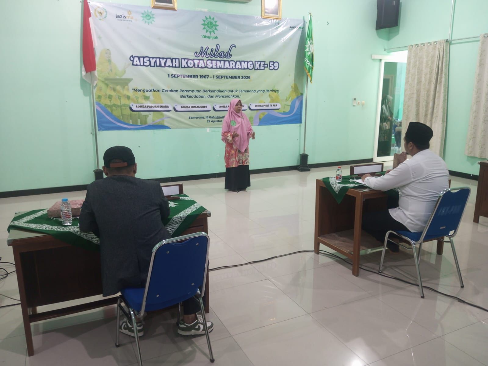 Peserta perempuan berhijab merah muda sedang berorasi di hadapan juri dalam Lomba Mubalighot pada acara Milad Aisyiyah Kota Semarang ke-59.