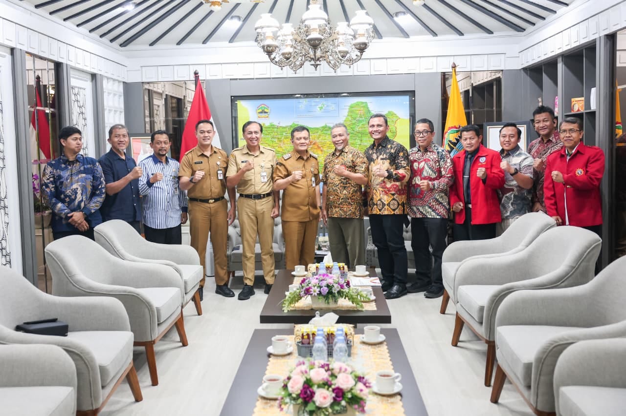 Jajaran panitia Muktamar XVI Tapak Suci, pimpinan Muhammadiyah, dan pejabat pemerintah daerah berfoto bersama memperagakan salam komando di ruang audiensi formal.