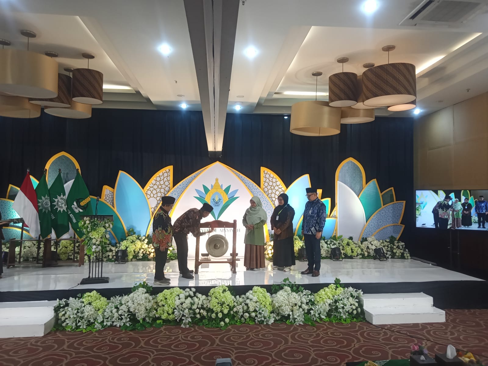 Ketua PP Muhammadiyah Agung Danarto memukul gong secara simbolis didampingi pimpinan Muhammadiyah dan Nasyiatul Aisyiyah di atas panggung utama bernuansa ornamen kelopak bunga biru-kuning.