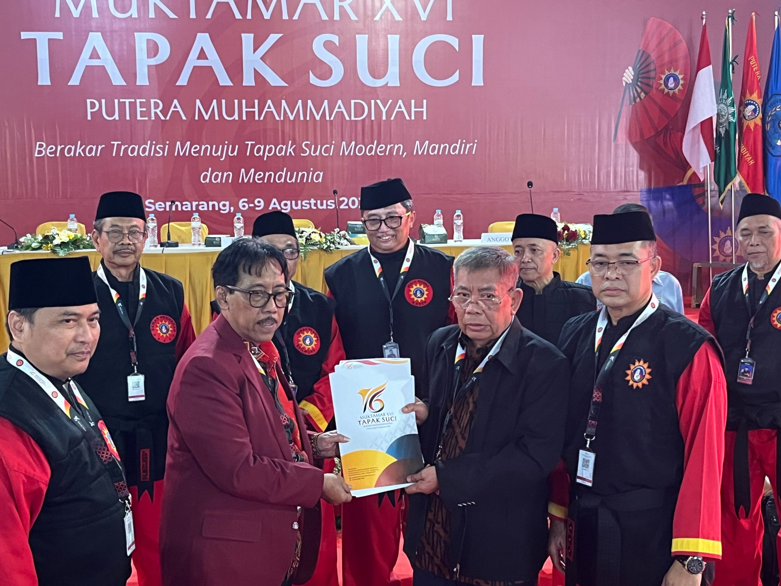 Afnan Hadikusumo menerima map berkas keputusan Muktamar Tapak Suci ke-16 secara simbolis disaksikan jajaran tim formatur dan dewan pendekar berseragam merah hitam.