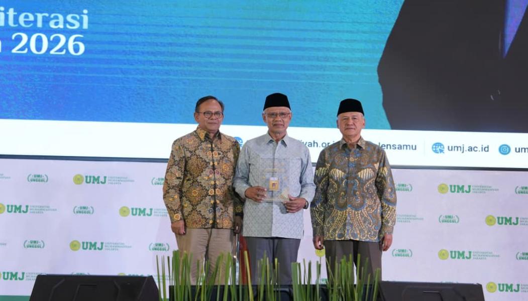 Ketua Umum PP Muhammadiyah Haedar Nashir berdiri di tengah memegang plakad penghargaan didampingi Ketua Dewan Pers Komarudin Hidayat dan pimpinan perguruan tinggi di atas panggung acara UMJ.