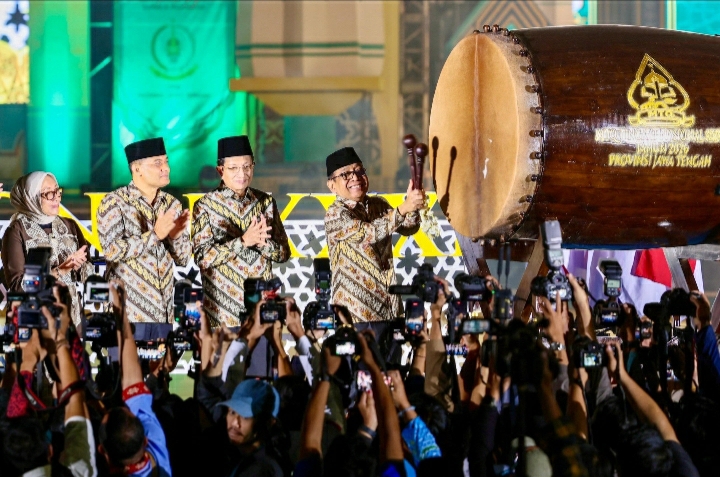 Empat pejabat pemerintah, termasuk Menko PMK Prof. Pratikno dan Gubernur Jawa Tengah Ahmad Luthfi, memukul bedug besar kayu untuk menandai pembukaan resmi MTQ Nasional XXXI 2026 di Semarang, disaksikan oleh lautan fotografer yang mengabadikan momen tersebut di malam hari.