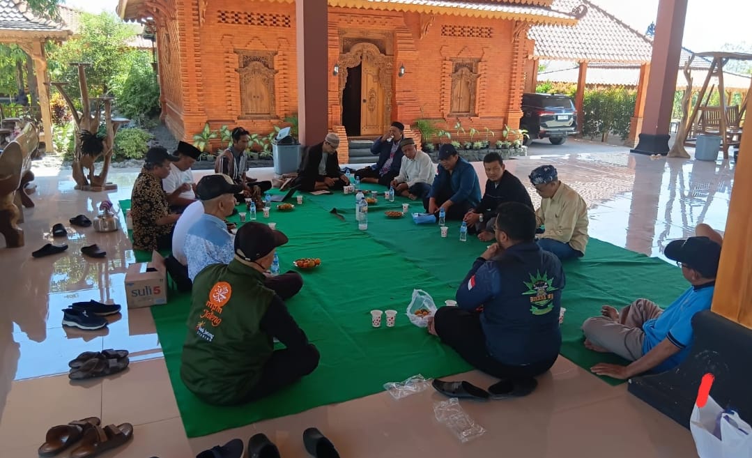 Jajaran panitia dan pengurus LDK PWM Jateng bersama perwakilan komunitas BikersMu duduk melingkar lesehan di atas karpet hijau teras Sanggar Cakraningrat Rembang yang berarsitektur bata merah tradisional.