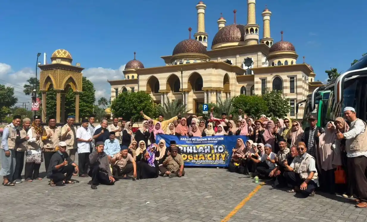 Rombongan 92 jemaah Pesantren Lansia Masjid At Taqwa Ngaliyan tersenyum memegang spanduk rihlah dengan latar belakang kemegahan arsitektur Masjid Al-Aqsha Klaten.