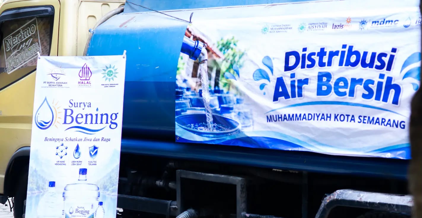 Truk tangki air bertuliskan spanduk Distribusi Air Bersih Muhammadiyah Kota Semarang terparkir berdampingan dengan standing banner Surya Bening.