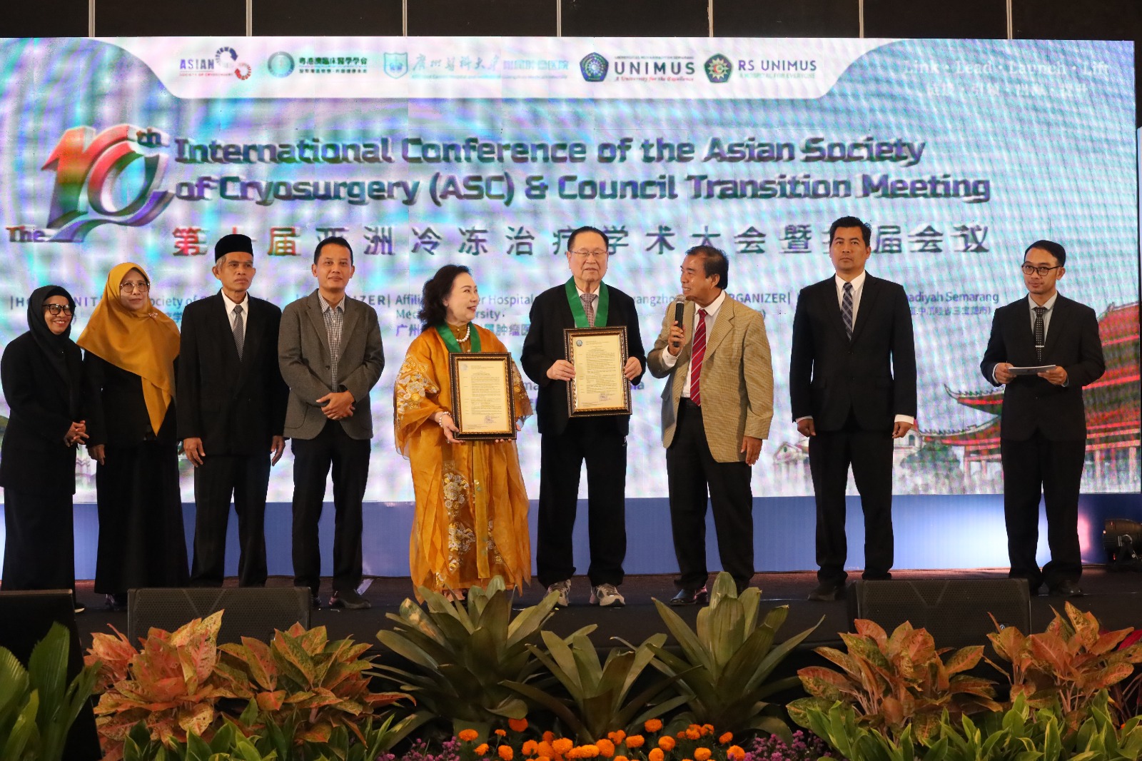 Jajaran pimpinan UNIMUS, tokoh medis internasional ASC, dan PP Muhammadiyah berdiri bersama di atas panggung penyerahan penghargaan berlatar layar LED konferensi internasional cryosurgery